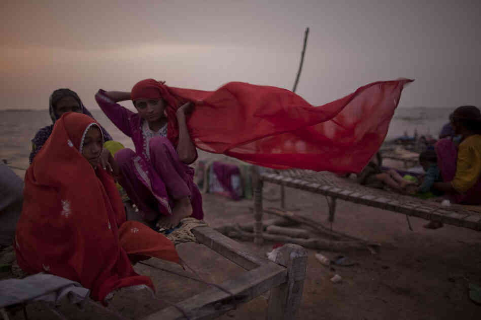 Young girls, whose families were displaced by floods, sit on a makeshift bed, as they take shelter on higher ground of a bund on August 29, 2010 in Thatta, near Hyderabad  in Sindh province, Pakistan.