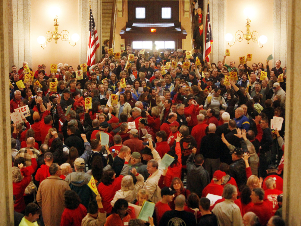 Hundreds of supporters for and against a bill that would restrict collective bargaining rights of public employees fill the Ohio Statehouse rotunda on Thursday in Columbus.