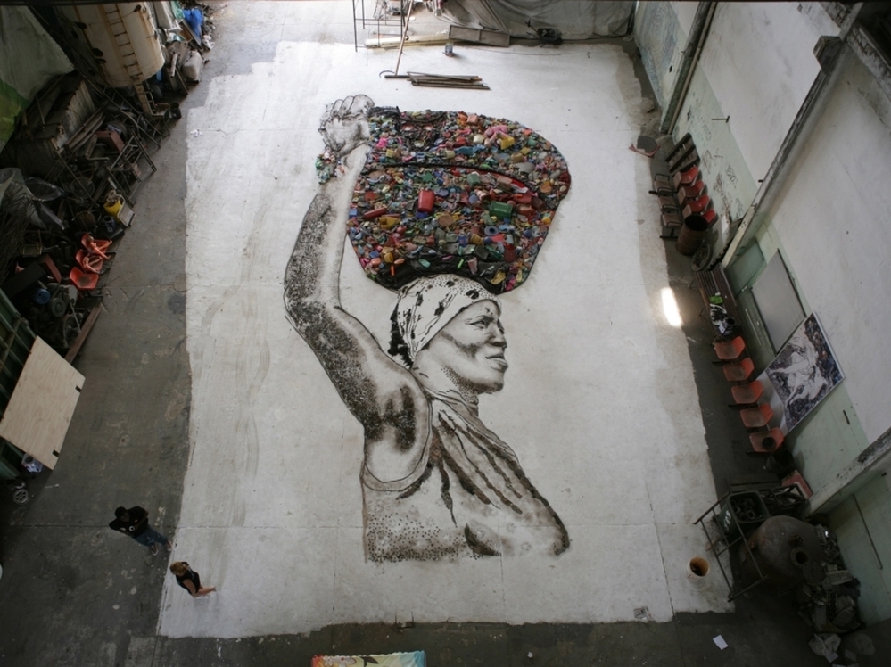 A massive portrait of Irma, resident chef at the Rio de Janiero landfill Jardim Gramacho, pieced together with scraps from the dump.