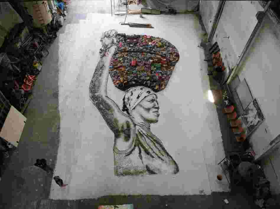 A massive portrait of Irma, resident chef at the Rio de Janiero landfill Jardim Gramacho, pieced together with scraps from the dump.
