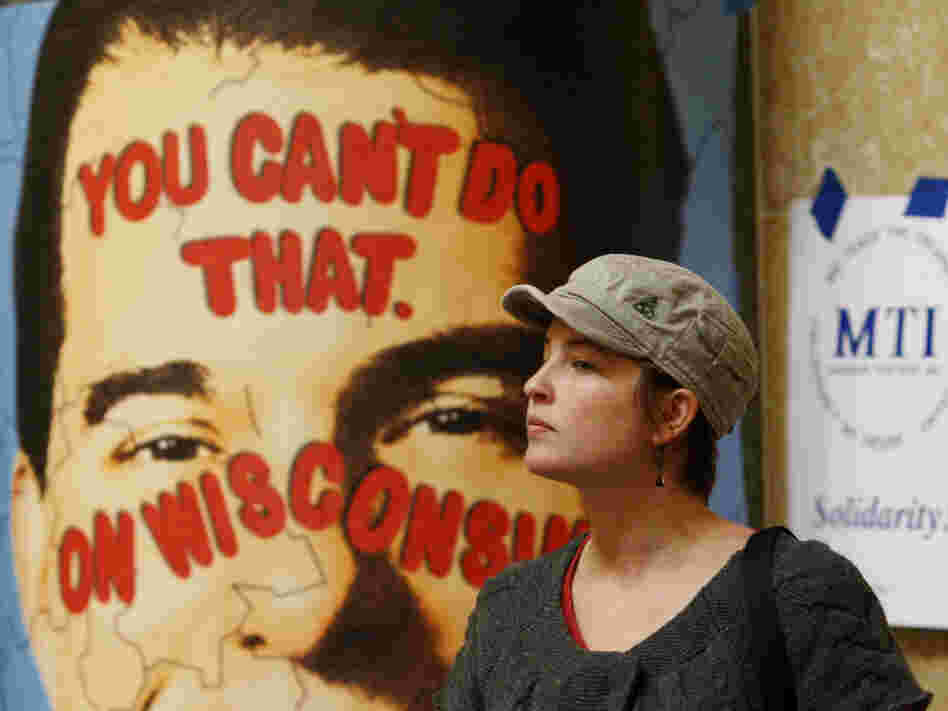 A protester looks on near a poster of Republican Gov. Scott Walker inside the state Capitol on Monday in Madison, Wis. Opponents to Gov. Walker's bill to eliminate collective bargaining rights for many state workers are taking part in their seventh day of protesting.