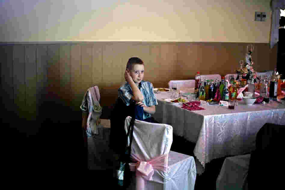 A young boy at a wedding reception above the firehouse in the village of Brzezinka.
