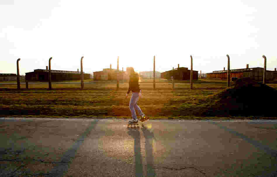 A girl skates along from the adjacent village of Brzezinka to the town of Oswiecim ("Auschwitz" in German). The road separates farmland and houses circling the camp museum.