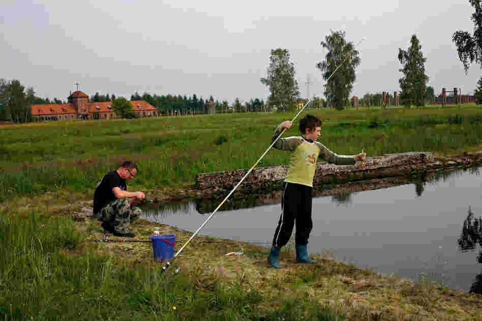 A father and son from the town of Brzezinka go fishing in flooded ruins of barracks at Auschwitz II-Birkenau.
