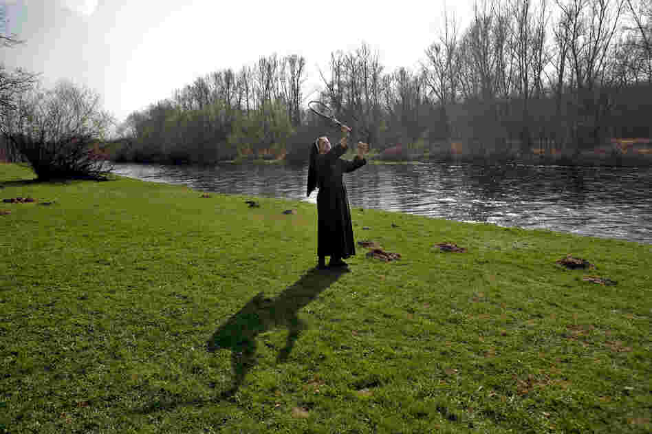 A nun plays badminton with school children on the banks of the Sola river in Oswiecim. About a mile down the river lies the concentration camp Auschwitz.