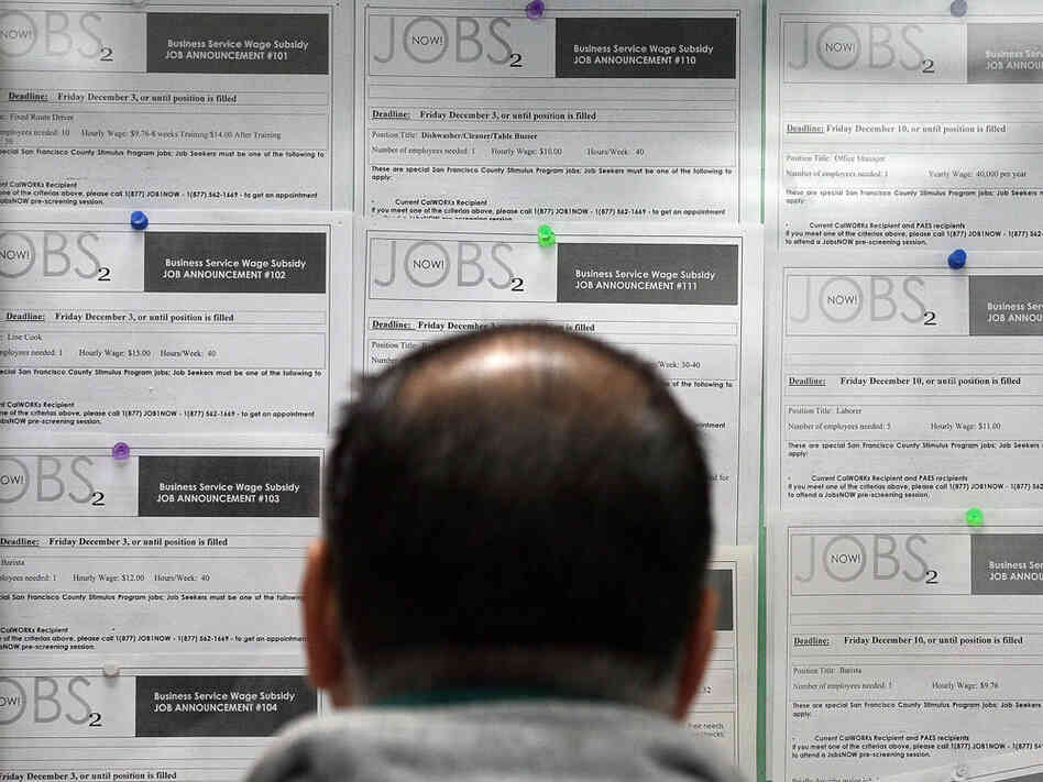 A job seeker looks at listings on a bulletin board. A job seeker looks at listings on a bulletin board.