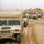 A U.S. Marines 2nd Division convoy moves past a tank equipped with a mine-clearing sled in Kuwait as the ground war gets under way Feb. 24, 1991.