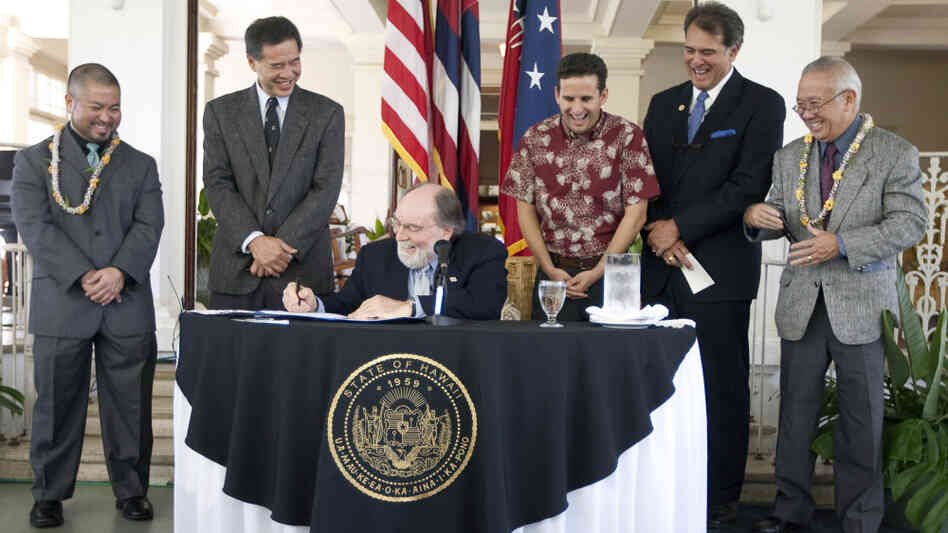 Hawaii lawmakers look on as   Hawaii Gov. Neil Abercrombie signs the Hawaii Civil Unions bill into law.