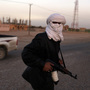 A Libyan policeman who defected to the side of anti-government protesters manned a checkpoint in the opposition-held, eastern city of Tobruk on Thursday.