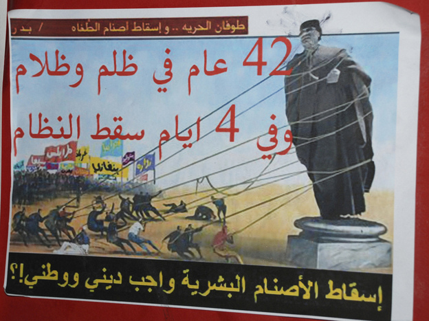 An anti-Gadhafi placard in Benghazi reads "A flood of freedom, topple the idols of oppression, 42 years of repression and darkness, in four days the regime fell, toppling the human idols is a religious and national duty".