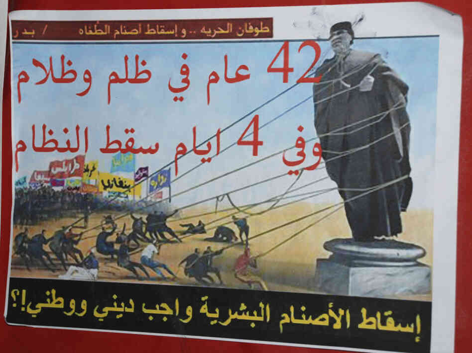An anti-Gadhafi placard in Benghazi reads "A flood of freedom, topple the idols of oppression, 42 years of repression and darkness, in four days the regime fell, toppling the human idols is a religious and national duty".