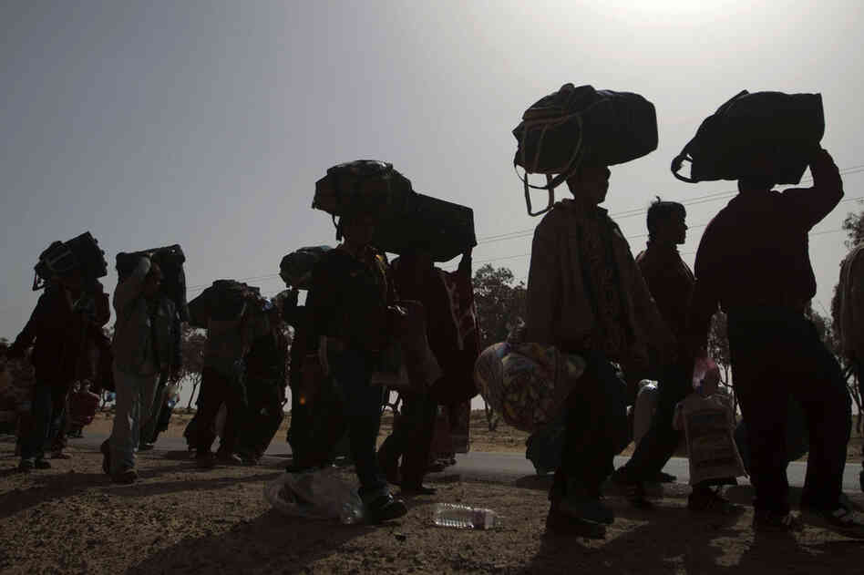 Thousands of Bangladeshi refugees who fled Libya stand in a miles-long line as they walk to a refugee camp in Tunisia on Friday.  