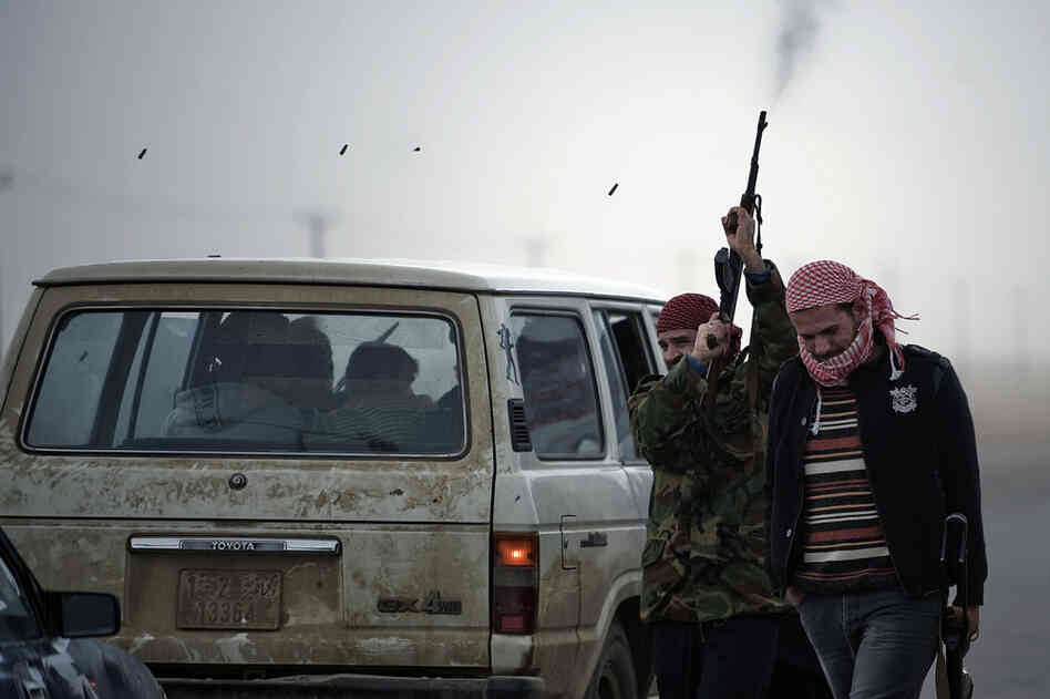 A Libyan rebel fighter fires his rifle in the air at Ajdabiya's west gate on Friday. 