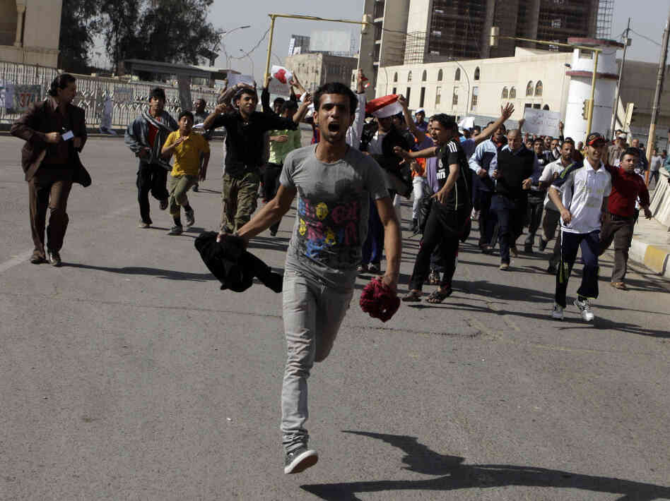 Protesters run as they chant anti-Iraqi government slogans during a protest in Baghdad's Tahrir Square. Hundreds of demonstrators converged on central Baghdad as part of a rally inspired by uprisings across the Middle East and dubbed the "Day of Rage."
