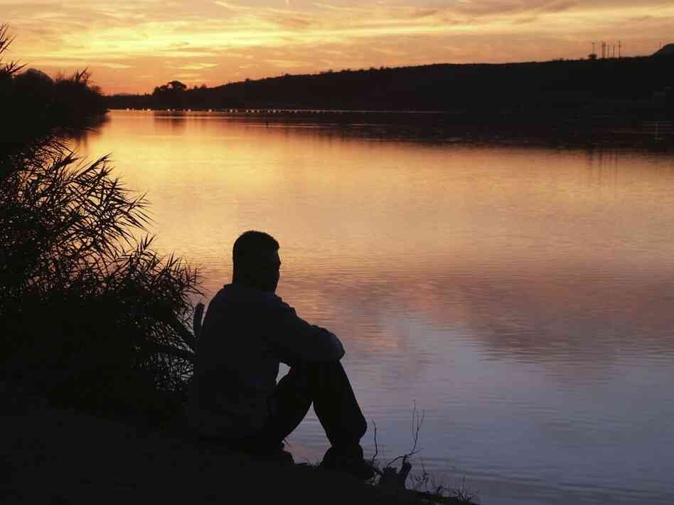 Man sitting by river. iStockphoto.com.