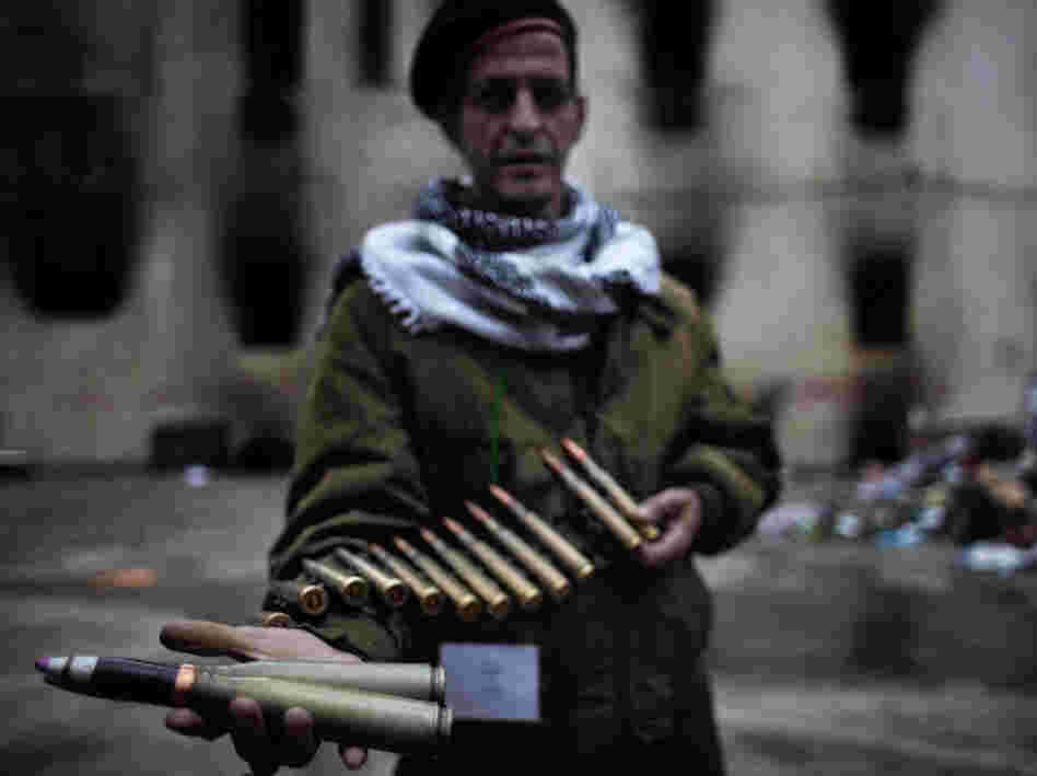 A Libyan rebel fighter displays heavy caliber ammunition found at a military barracks in Benghazi on Sunday.