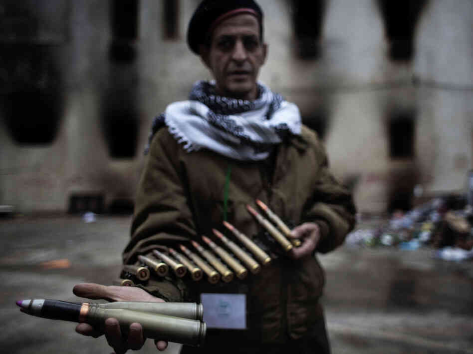 A Libyan rebel fighter displays heavy caliber ammunition found at a military barracks in Benghazi on Sunday.
