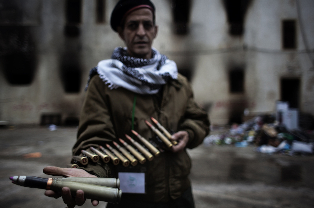 A Libyan rebel fighter displays heavy caliber ammunition found at a military barracks in Benghazi on Sunday.
