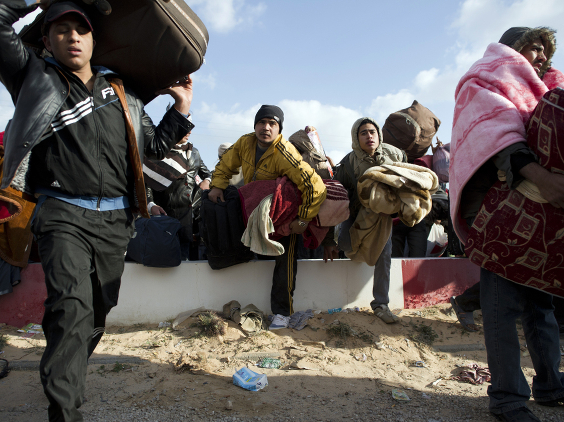 Egyptian people fleeing Libya race to get on buses at the Ras Jedir border post, near the Tunisian city of Ben Guerdane, on Sunday.