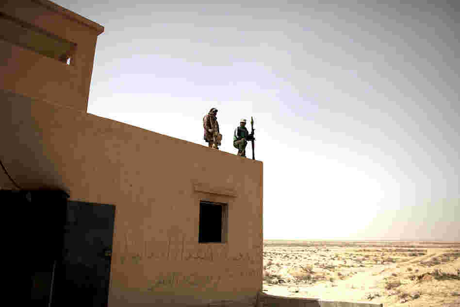 Defected Libyan soldiers stand guard outside an army base in the eastern town of Ajdabiya, Libya, on Tuesday. Eastern cities are free from government control, but fighting continues around the capital Tripoli, controlled by Libyan leader Moammar Gadhafi. 