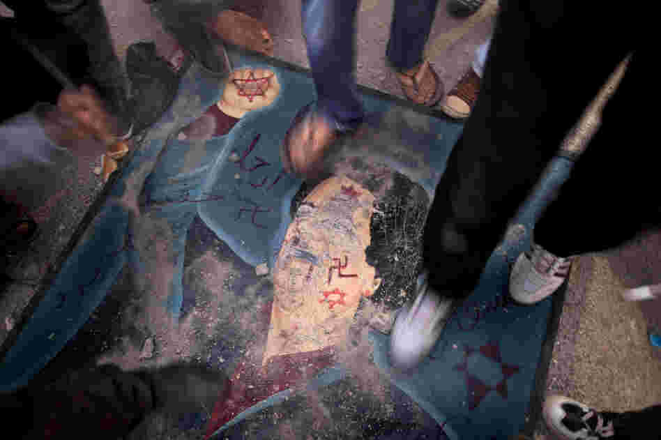 Libyans stomp on a defaced billboard of Gadhafi during a demonstration against his regime in the city of Tobruk on Saturday. 