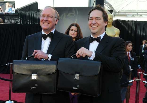 Rick Ross (L) and Brad Oltmann of Price Waterhouse Cooper arrive with briefcases containing the winners' envelopes.
