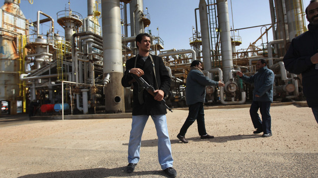 A militiaman stands guard at a Libyan oil refinery in the rebel-held territory of al-Brega on Feb. 27. The opposition leadership has stressed that oil facilities in areas under its control are safe, despite the conflict roiling the country.