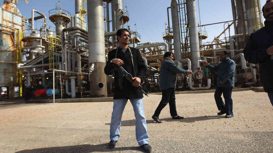 A militiaman stands guard at a Libyan oil refinery in the rebel-held territory of al-Brega on Feb. 27. The opposition leadership has stressed that oil facilities in areas under its control are safe, despite the conflict roiling the country.
