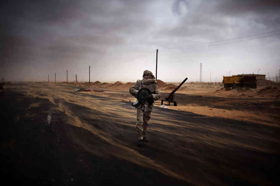 A rebel fighter stands at a checkpoint Saturday in Ras Lanuf, where up to 10 people were killed and more than 20 wounded in clashes between opposition forces and Gadhafi loyalists. 