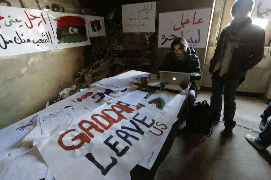 Volunteers work on anti-Gadhafi banners at the newly set-up media center in Benghazi, Libya, on Monday. Libyan activists provide technical support and documents to journalists. 