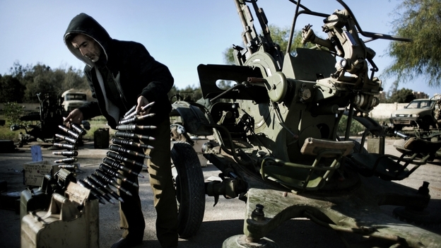 A Libyan civilian holds anti-aircraft ammunition at an army barracks in Benghazi, where dozens of civilians registered for civil defense  training amid fears of air raids from Tripoli.