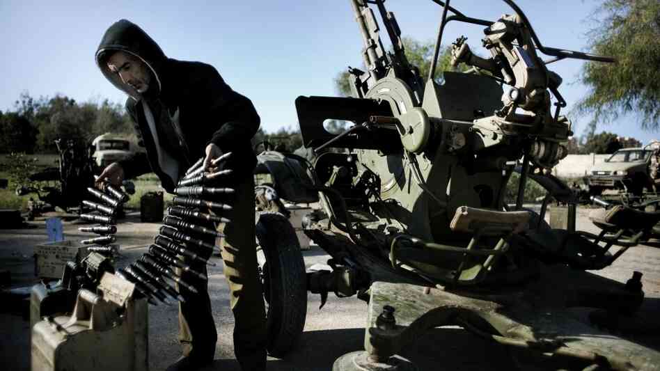 A Libyan civilian holds anti-aircraft ammunition at an army barracks in Benghazi, where dozens of civilians registered for civil defense  training amid fears of air raids from Tripoli.