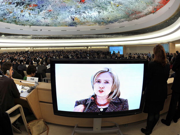 U.S. Secretary of State Hillary Clinton is seen on a TV screen while delivering a speech Monday before the United Nations Human Rights Council in Geneva.