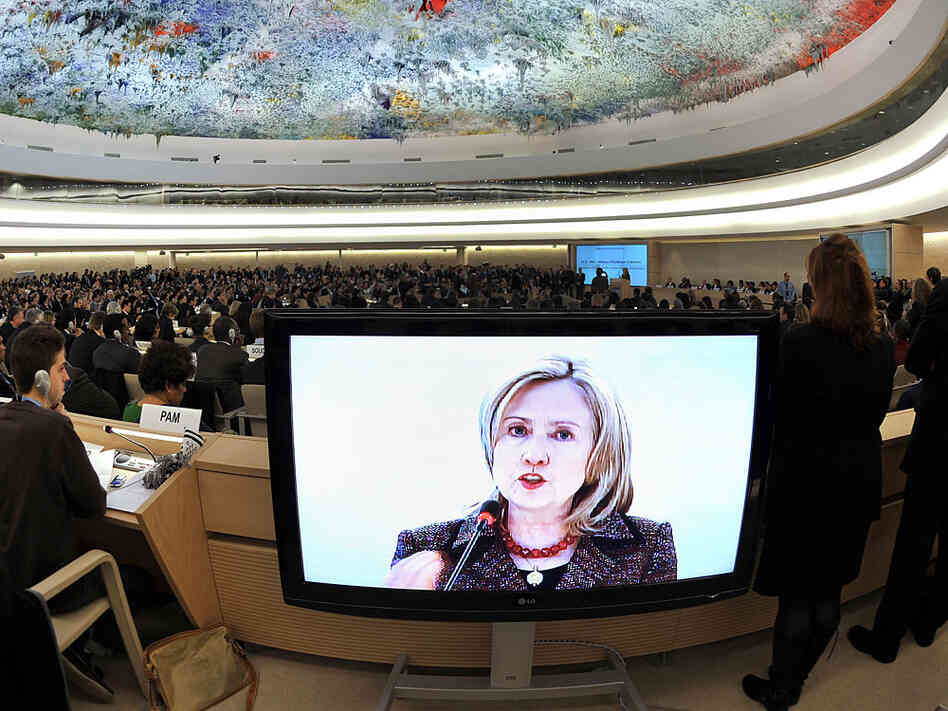 U.S. Secretary of State Hillary Clinton is seen on a TV screen while delivering a speech Monday before the United Nations Human Rights Council in Geneva.