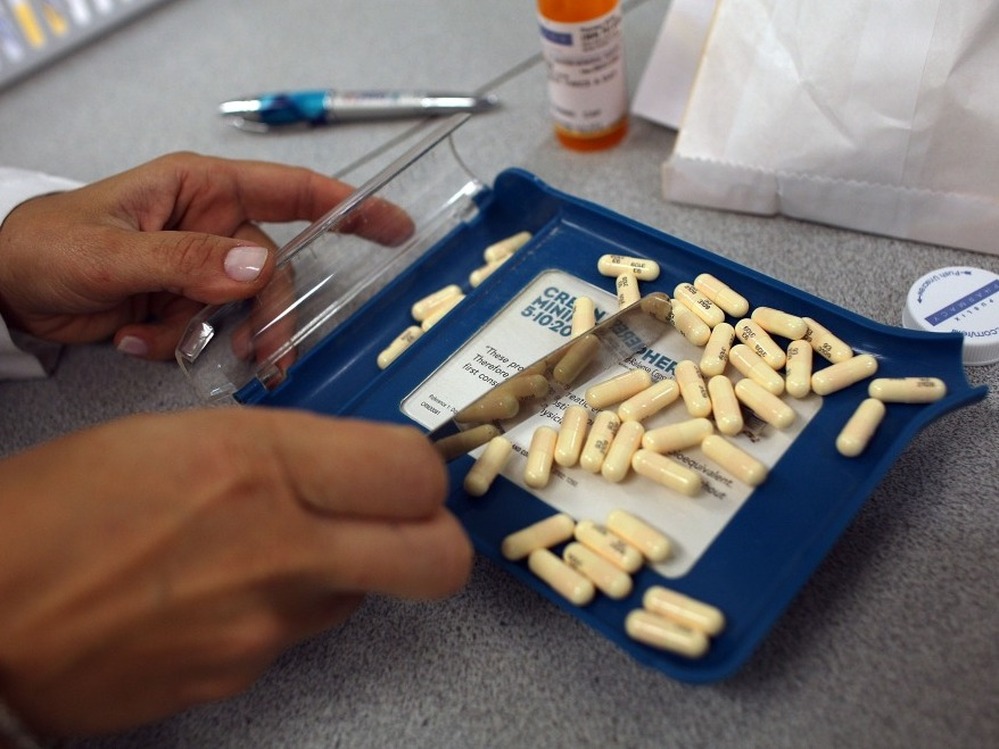 A pharmacy manager counts out the correct number of pills to fill a prescription  in Miami.