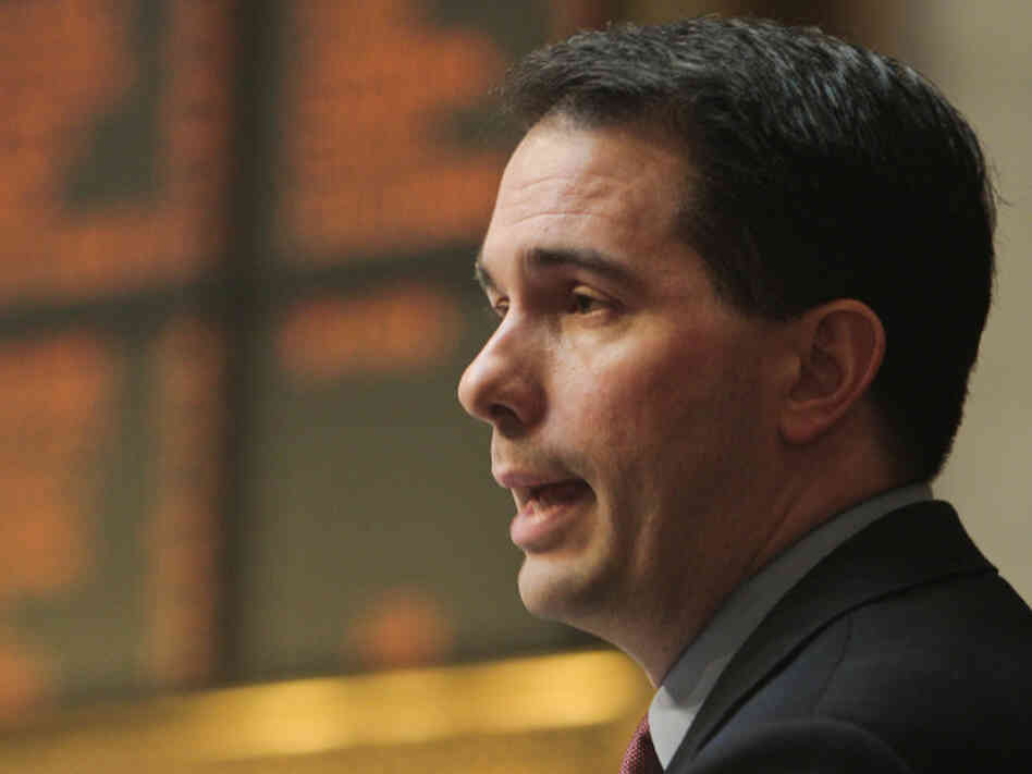 Wisconsin Gov. Scott Walker discusses his budget during a joint session of the Legislature at the state Capitol in Madison on Tuesday. Opponents to the governor's bill to cut collective bargaining rights for state workers have been protesting the governor's plans for two weeks at the Capitol.