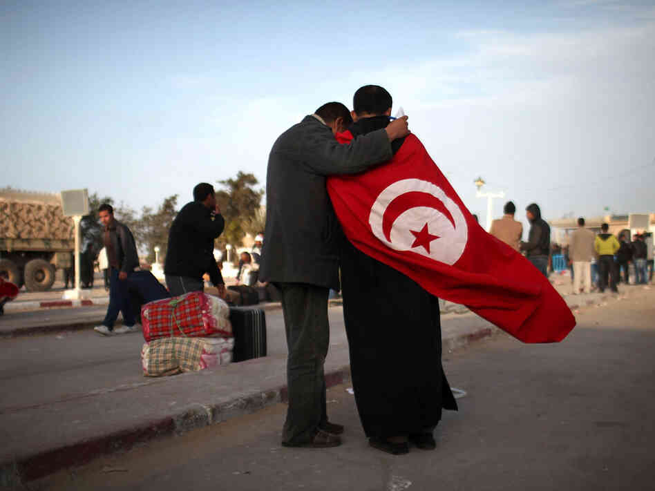 Two men stand at the border of Libya in Ras Jdir, Tunisia, on Monday. Two men stand at the border of Libya in Ras Jdir, Tunisia, on Monday.