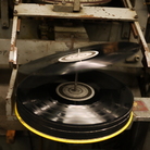 A 12-inch record tips onto the spindle at EKS Manufacturing. A 12-inch record tips onto the spindle at EKS Manufacturing.