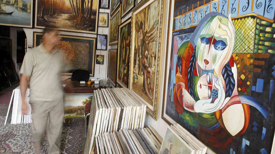 An Iraqi man walks past paintings displayed at a gallery in the Karrada district of central Baghdad on April 13, 2010. An Iraqi man walks past paintings displayed at a gallery in the Karrada district of central Baghdad on April 13, 2010.