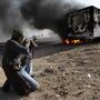 Celebrating victory in the battle for Brega, a Libyan rebel fighter takes aim at a burning vehicle that was used by troops loyal to Moammar Gadhafi.