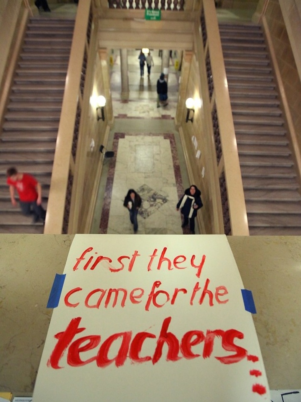 A sign supporting teachers is taped to the railing above a stairway in the Wisconsin state Capitol last month, as activists protested what they call an anti-union measure.