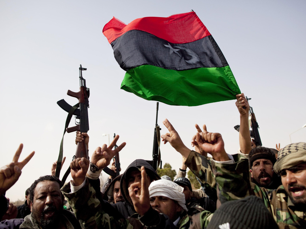 Libyan rebels fly a flag from the days before Gadhafi rule as they celebrate the capture of Ras Lanuf in eastern Libya on Saturday.