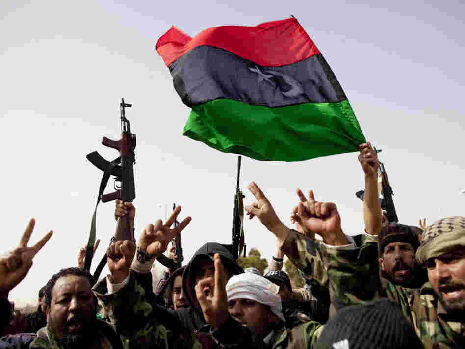 Libyan rebels fly a flag from the days before Gadhafi rule as they celebrate the capture of Ras Lanuf in eastern Libya on Saturday.