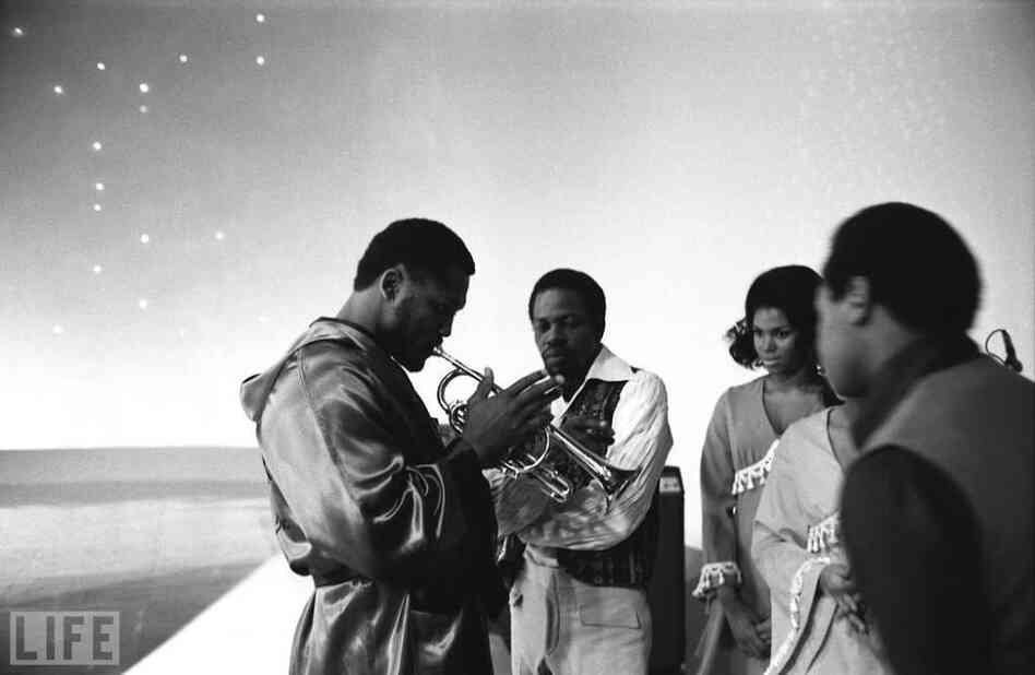 Joe Frazier tests out a band member's trumpet on the set of NBC's long-running Kraft Music Hall variety show, one of many stops on the media circuit preceding the fight. Joe Frazier tests out a band member's trumpet on the set of NBC's long-running Kraft Music Hall variety show, one of many stops on the media circuit preceding the fight.