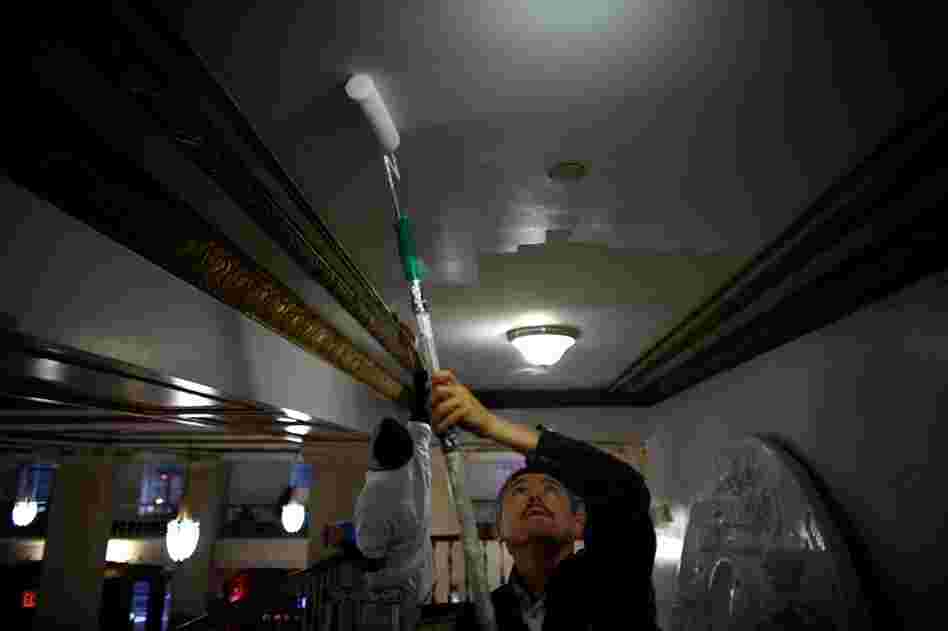 Building maintenance man Arif Yalcin paints the ceilings in the lobby. Along with the Center for Urban Community Services, the Times Square Building combines permanent affordable housing with social services.