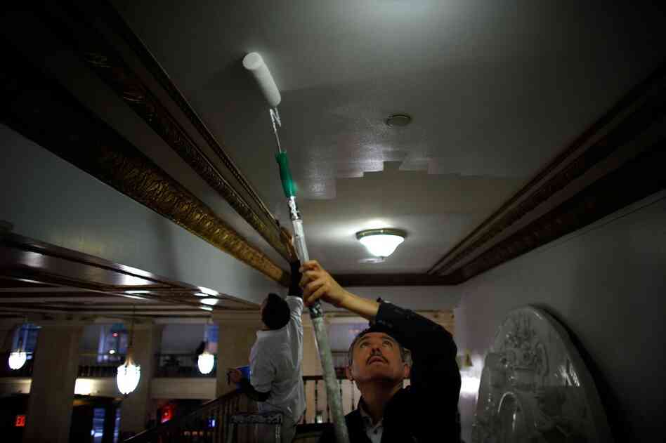 Building maintenance man Arif Yalcin paints the ceilings in the lobby. Along with the Center for Urban Community Services, the Times Square Building combines permanent affordable housing with social services.