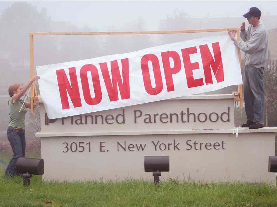 Workers hang a banner signaling the opening of a Planned Parenthood clinic in Aurora, Illinois in October of 2007. The clinic was a source of contention between abortion rights advocates and abortion rights opponents in the community, and last-minute legal challenges had delayed the clinic's opening. Workers hang a banner signaling the opening of a Planned Parenthood clinic in Aurora, Illinois in October of 2007. The clinic was a source of contention between abortion rights advocates and abortion rights opponents in the community, and last-minute legal challenges had delayed the clinic's opening.