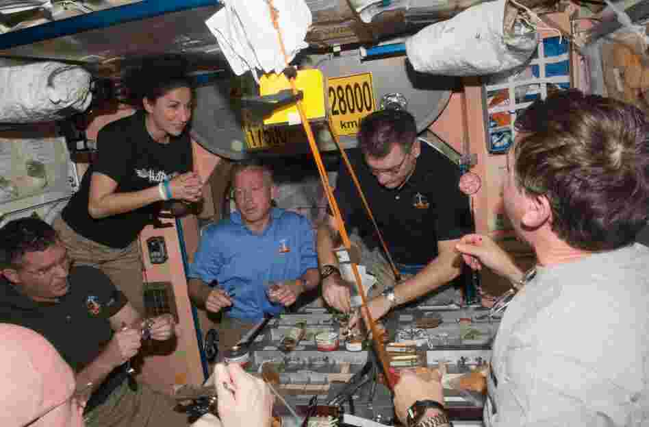 Space station and Discovery crew members share a meal. From left: Steve Bowen, Nicole Stott, Steve Lindsey, Paolo Nespoli and Michael Barratt.
