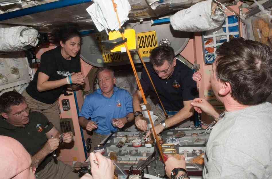 Space station and Discovery crew members share a meal. From left: Steve Bowen, Nicole Stott, Steve Lindsey, Paolo Nespoli and Michael Barratt.