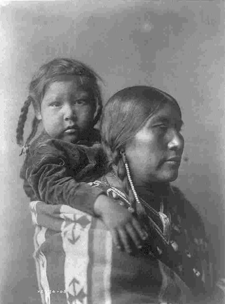 Arapsoke woman with a child secured on her back with a blanket. Arapsoke woman with a child secured on her back with a blanket.